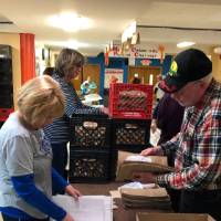 Volunteers take the time to organize the boxes at Kids' Food Basket.
